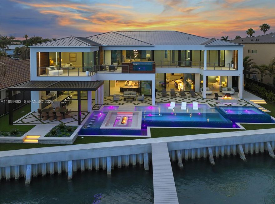 Built by award-winning High Tide Waterfront Properties on Jupiter's iconic Bahamian-blue Intracoastal, this brand-new residence delivers a true sense of arrival with standout design and thoughtful execution throughout. From the moment you enter, your eye is drawn through the home to the beautiful blue water views beyond, setting the tone for the living experience inside. Expansive living spaces are finished with high-end materials and meticulous attention to detail. High Tide is known for thoughtfully building homes that make the experience of living in them unmatched, and this property is no exception. Designed for entertaining, the backyard features multiple fire pits, a fully equipped outdoor kitchen, a waterfall feature, and inviting spaces to gather and relax along the water, creating