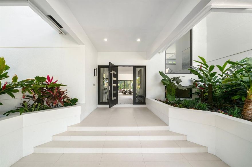 Contemporary 6,760 SF residence with 5 BD and 5.5 BA on a sizable 18,055 SF lot, in the highly sought-after gated community of Cocoplum. Substantially remodeled in 2021, the two-story home showcases voluminous ceilings and an open layout offering plenty of natural light. The gourmet eat-in kitchen features custom floor-to-ceiling cabinetry, ample storage, gas range, high-end appliances, and Grohe carbonated water filter system. The kitchen and family room open seamlessly to outdoor entertainment areas and a beautiful backyard, including a pool with jacuzzi, terraces with retractable awnings, summer kitchen, and stunning tropical landscaping. Additional features include impact windows and doors, office with glass enclosure, media room, and 2-car garage with epoxy flooring.