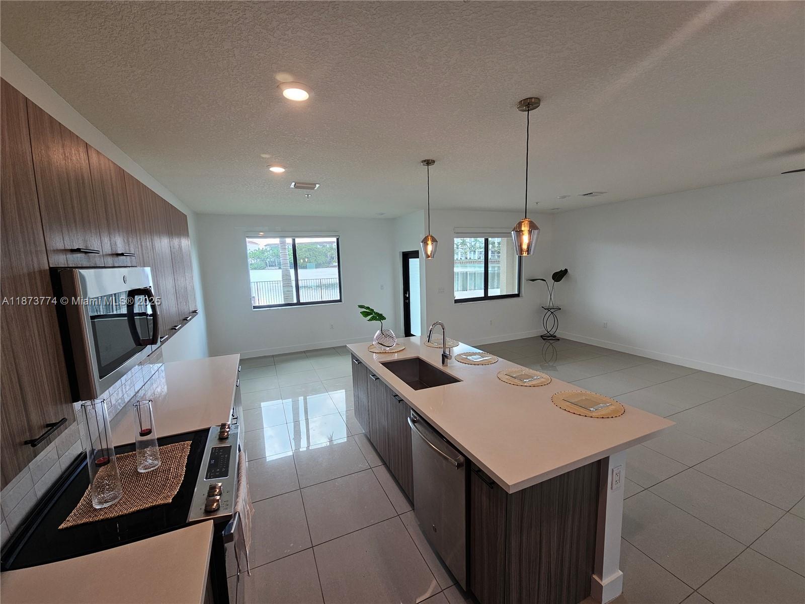 Experience lakeside luxury in this 2-story unit at the desirable Urbana Residences. With 3 beds and 2.5 baths, this home features a modern open floor plan and elegant tile flooring throughout. The chef-inspired kitchen offers quartz countertops, SS appliances, and custom cabinetry. Enjoy beautiful Lake Osprey views from the primary suite (private balcony) and a second bedroom. Features include high-impact windows and doors, in-unit laundry, 1 reserved parking space, and an extra guest spot. The property offers resort-style amenities, including a fitness center, indoor basketball court, running track, splash pad, pool, and event spaces. Just steps from top-rated schools, fine dining, shopping, golf courses, parks, and entertainment, this home provides ultimate convenience and lifestyle.