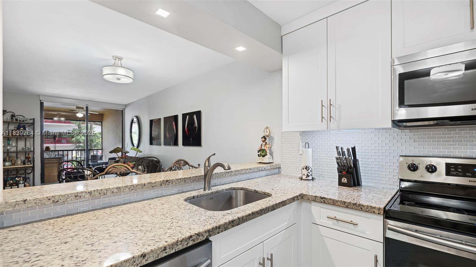 Nestled in the heart of Miami Lakes, this elegantly remodeled, turn key 2 bedroom, 1.5 bath condo exudes sophistication and contemporary style, featuring a modern kitchen with granite countertops, new stainless steel appliances and added cabinetry; timeless white tile flooring throughout; beautifully updated bathrooms with high end finishes; built in closets; impact windows; an in unit washer and dryer; and a private screened patio that offers a pleasant outdoor retreat, with water included in the HOA dues. Set within a well maintained, scenic community offering 24 hour security, a resort style pool and roof maintenance, this home provides a seamless blend of style, convenience and Miami Lakes charm, all just moments from shopping, dining, entertainment and major highways.