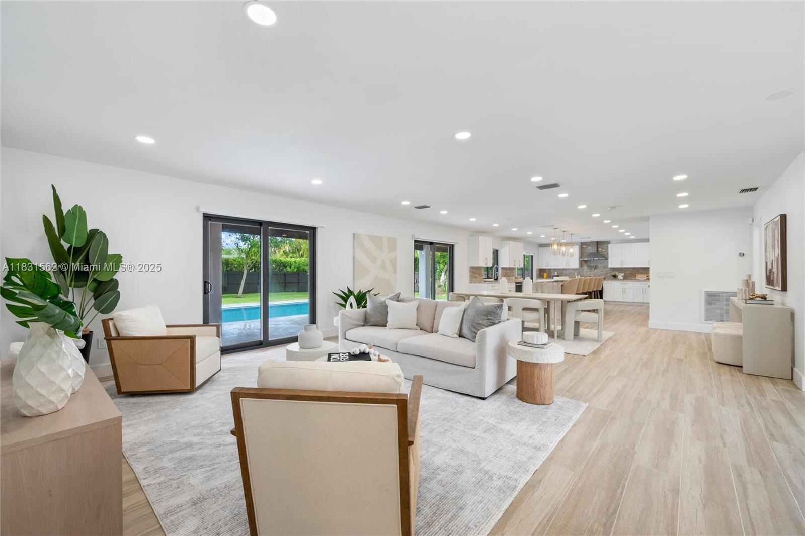 Impeccably renovated 4-bed + den blends modern comfort with timeless style on an oversized corner lot at the entrance of a quiet cul-de-sac. The open floor plan offers expansive living and dining areas filled with natural light. The kitchen overlooking the pool features custom cabinetry, stainless steel appliances, striking Taj Mahal quartzite counters, and a large island for entertaining. The primary suite includes a beautiful ensuite bath, spacious closet, and direct access to the resort-style backyard. Outdoors, enjoy privacy with mature landscaping, pool, marble flooring, and space to unwind. Additional highlights: new porcelain floors, impact windows and doors, metal roof, updated A/C, plumbing, and electrical. Attached garage with epoxy floors and new washer/dryer.
