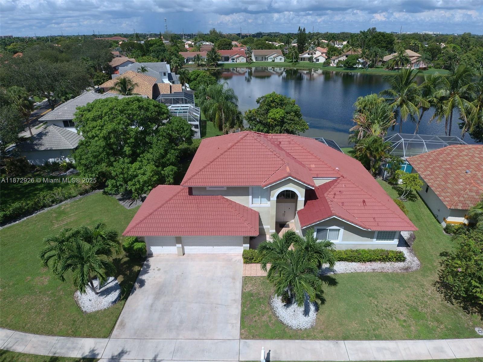 Lakefront with screened Pool on oversized, fruit-laden, corner lot over 1/4 acre! Four (4 ) large bedrooms with four (4) full bathrooms. The Primary Suite (Master) is on the ground floor, along with a 2nd bedroom currently used as an office. The 3-car garage and driveway provide ample parking. Expansive layout. Among the largest models in The Landings! Lakefront and with a screened porch for you to entertain your friends and family, or to simply relax. Established neighborhood with very low HOA fees at just $100 per month. Primary (Master Suite) & even a 2nd Bedroom on 1st floor for easy access. Roof replaced in 2018. Laundry room under air. Competitively priced for Pembroke Pines - show and sell.