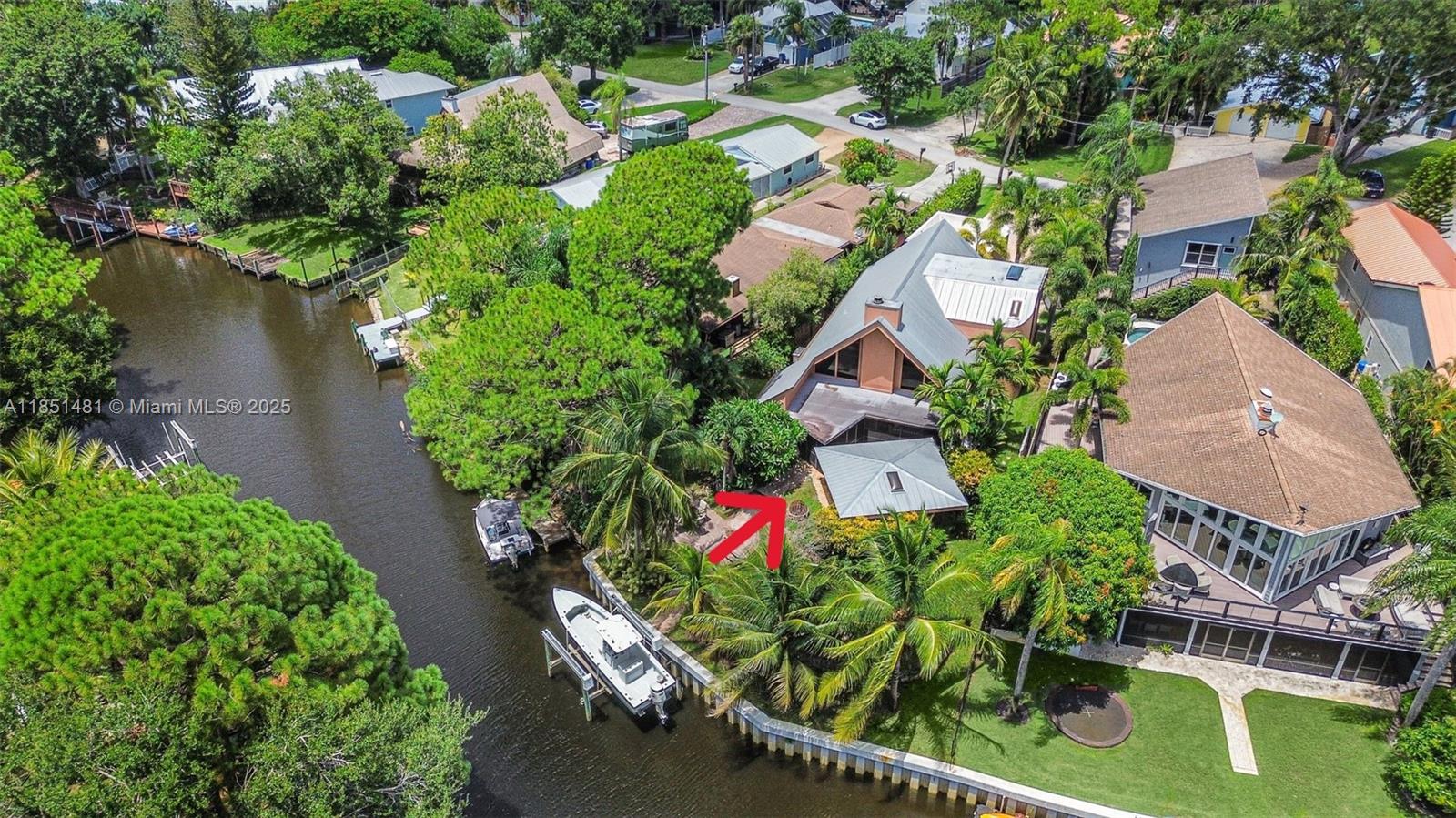 A tropical waterfront oasis like no other!!! This is a beautiful secluded home with a private boat dock in Rustic Hills. Rustic Hills was originally a popular fishing camp, now a quaint enclave of 178 canal front homes. Neighborhood entrance is through a covered bridge. Spacious 3 bedrooms with a loft, 2 baths, 2 story home with detached garage. Great view of the canal with approximately 80 feet of waterfront with a brand new seawall. Covered patio area with in-ground hot tub/ cocktail pool that is perfect for entertaining with a fire pit. Exquisite lush landscaping is truly breathtaking. Custom wood cabinetry and granite counters in the kitchen. Wood burning fireplace in the living room. A-rated Palm City schools, Martin County School District. Easy access to I-95 & FL turnpike.