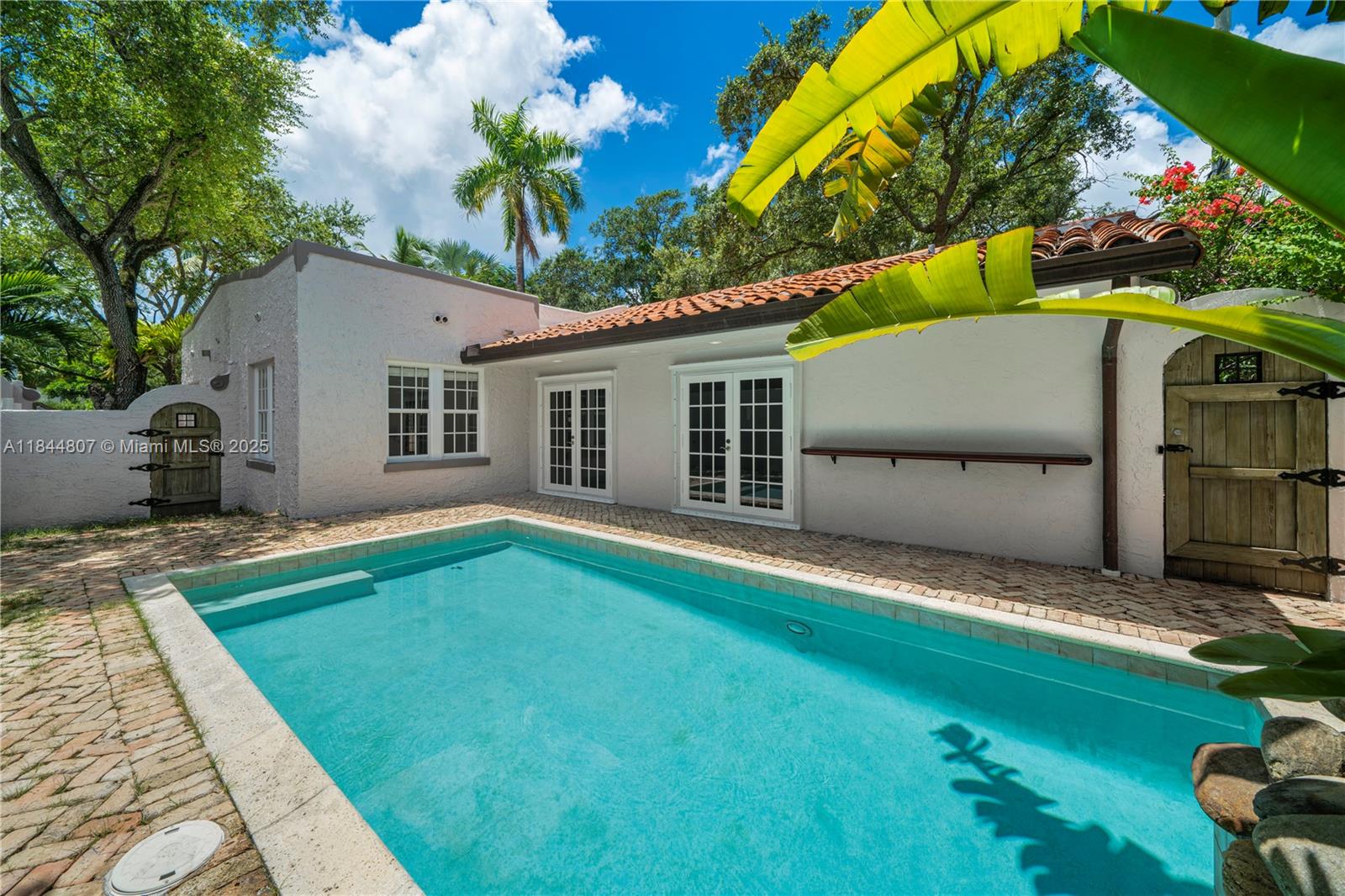 Charming & fully renovated 3-bed, 2-bath Old Spanish-style home in sought-after North Coconut Grove. This bright & inviting residence showcases soaring ceilings, rich oak wood floors, & a formal living room w/ working fireplace. The spacious dining/family room includes a cozy den, while the sunlit breakfast nook opens directly to the private pool & patio area. The updated kitchen is outfitted w/ custom cabinetry, granite countertops, & new stainless steel appliances, including a wine cooler & under-counter ice maker—ideal for entertaining. The serene primary suite overlooks the pool, & the spa-inspired bath features a Jacuzzi tub & walk-in shower. Additional highlights include a home security system w/ cameras & an estimated 2,200 SF of living space per engineer’s drawings.
