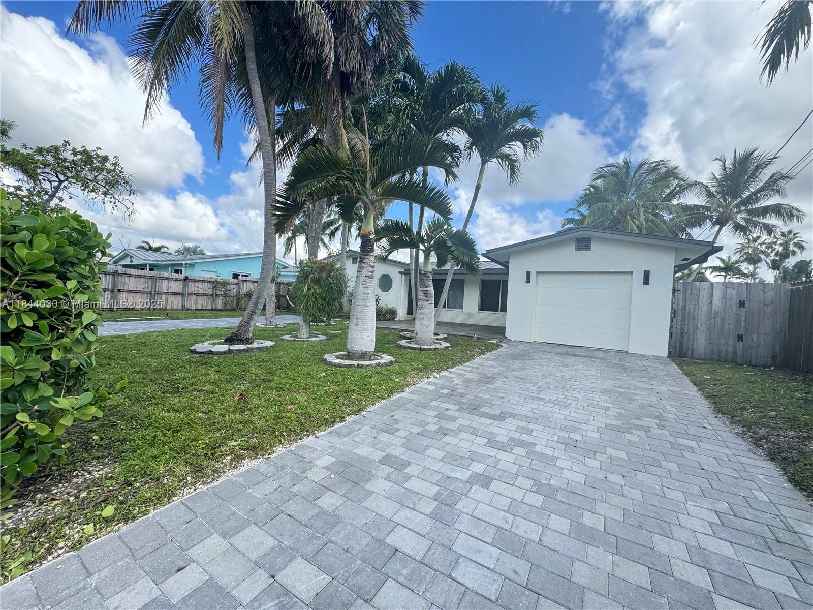 Discover this beautifully renovated 3-bedroom, 2-bath waterfront home with no fixed bridges and direct ocean access — just minutes from downtown Fort Lauderdale, the airport, and the beaches. The house has a 2024 metal roof with high impact windows and doors. Enjoy your own 60 ft dock, plus a heated pool and spa for year-round enjoyment. Inside, you'll find porcelain tile floors and recessed lighting throughout. The open-concept layout is flooded with natural light, and both the kitchen and living room overlook the pool canal. The spacious kitchen features granite countertops, stainless steel appliances, and room for a cozy breakfast nook. There's also a dedicated dining area for entertaining guests. The 1-car garage is ideal for a golf cart, motorcycles, bikes, or extra storage.