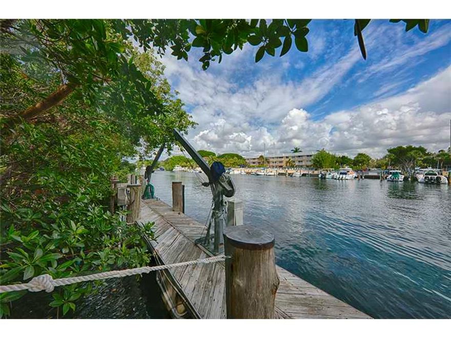 Best value for updating, great for large yacht, no bridges to Bay. Wide Gables Waterway, 22,730 sf lot, approx. 80 ft dock. Very private home not visible from street, at end of gated driveway.Room to add value on desirable waterway and oversized lot. Great ceiling heights,  floor plan,ready for updates. Open lay out with Living/Dining Great Room open to covered terrace. Kitchen and breakfast room, open to family/bar.Functional floor plan with downstairs master suite, plus office/library, 1/1 staff.4 upstairs bedroom suites. Sq Ft as per tax roll.