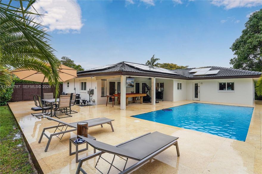 Turn-key modern residence located on a quiet private cul-de-sac with serene canal views. This 4-bedroom, 2-bath home features a stunning modern kitchen with white quartz waterfall island, high-gloss cabinetry, induction cooktop, farmhouse sink, and newer appliances. Spacious primary suite offers walk-in closet and spa-style porcelain bath with soaking tub. Bright living areas flow to the outdoors, where you’ll find a new saltwater pool (Dec 2025) with marble deck, heater, and covered terrace overlooking the canal. Fully fenced yard with mature fruit trees and extended driveway. Remodeled garage includes washer/dryer combo, Tesla EV charger, new subpanel, and electric water heater. Additional highlights: Tesla solar panels powering the home, impact windows/doors, 5-ton AC, 7-year-old roof, Starlink internet, and full ADT security system. A rare blend of luxury, efficiency, and waterfront living.