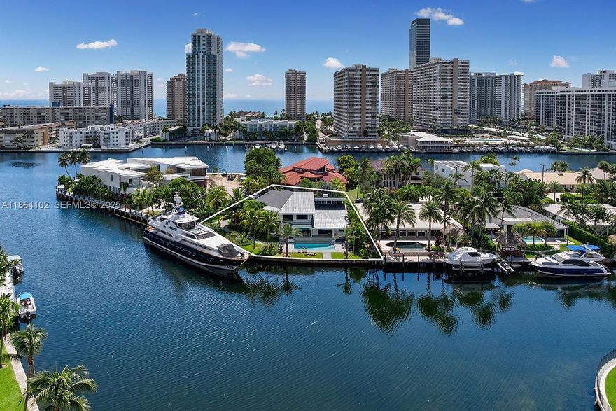 Welcome to an extraordinary, one-of-a-kind waterfront estate in the exclusive gated enclave of Golden Isles, in the heart of Hallandale Beach. This beautifully renovated two-story point lot residence spans ~5,300 SF of refined living space and offers 4 bedrooms, 3 baths, and luxurious indoor-outdoor living with vaulted ceilings, walk-in closets, marble and ceramic floors, and lush landscaping. Set on a 16,100 SF corner lot with over 180 feet of waterfront, the home boasts sweeping Intracoastal views from every level. A 100-foot private dock accommodates large yachts and offers direct ocean access with no fixed bridges—a true boater’s paradise. A rare coastal jewel offering the ultimate South Florida waterfront lifestyle.