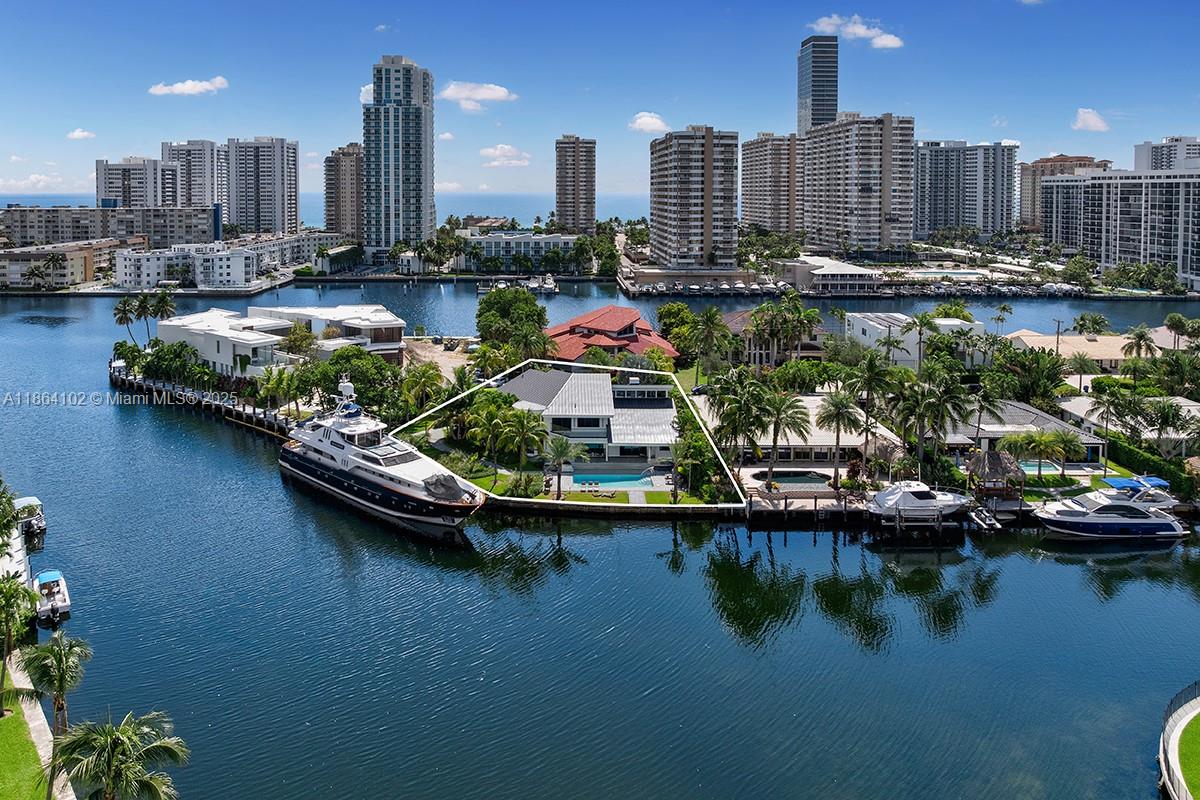 Welcome to an extraordinary, one-of-a-kind waterfront estate in the exclusive gated enclave of Golden Isles, in the heart of Hallandale Beach. This beautifully renovated two-story point lot residence spans ~5,300 SF of refined living space and offers 4 bedrooms, 4 baths, and luxurious indoor-outdoor living with vaulted ceilings, walk-in closets, marble and ceramic floors, and lush landscaping. Set on a 16,100 SF corner lot with over 180 feet of waterfront, the home boasts sweeping Intracoastal views from every level. A 100-foot private dock accommodates large yachts and offers direct ocean access with no fixed bridges—a true boater’s paradise. A rare coastal jewel offering the ultimate South Florida waterfront lifestyle.