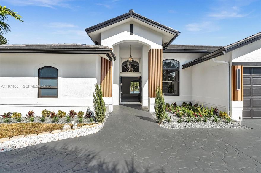 Welcome to this exceptional estate in the prestigious Kapok Village Estates in Davie.  New roof Situated on a private over one-acre homesite, this beautifully renovated 3,560 SF residence offers timeless elegance, modern upgrades, and a resort-style lifestyle with tranquil lake views. The home features 4 spacious bedrooms, 3 fully renovated designer baths, and a private office/den. Soaring ceilings, expansive living and dining areas, and abundant natural light create an open, sophisticated flow ideal for everyday living and entertaining. The reimagined gourmet kitchen showcases high-end appliances, custom cabinetry, and contemporary finishes. New flooring runs throughout, enhancing the cohesive, upscale design. Recent upgrades include full impact windows and doors and a brand-new roof for added durability and energy efficiency.
Outdoor living is equally impressive with a sparkling pool, heated spa, and fully equipped summer kitchen overlooking the water. The expansive grounds provide privacy and ample space to relax or entertain. A 3-car garage and oversized driveway offer generous parking.
Ideally located near top-rated schools, shopping, dining, major highways, and Long Key Natural Area & Nature Center, this move-in-ready estate blends prestige, comfort, and convenience in one of Davie’s most desirable communities.
