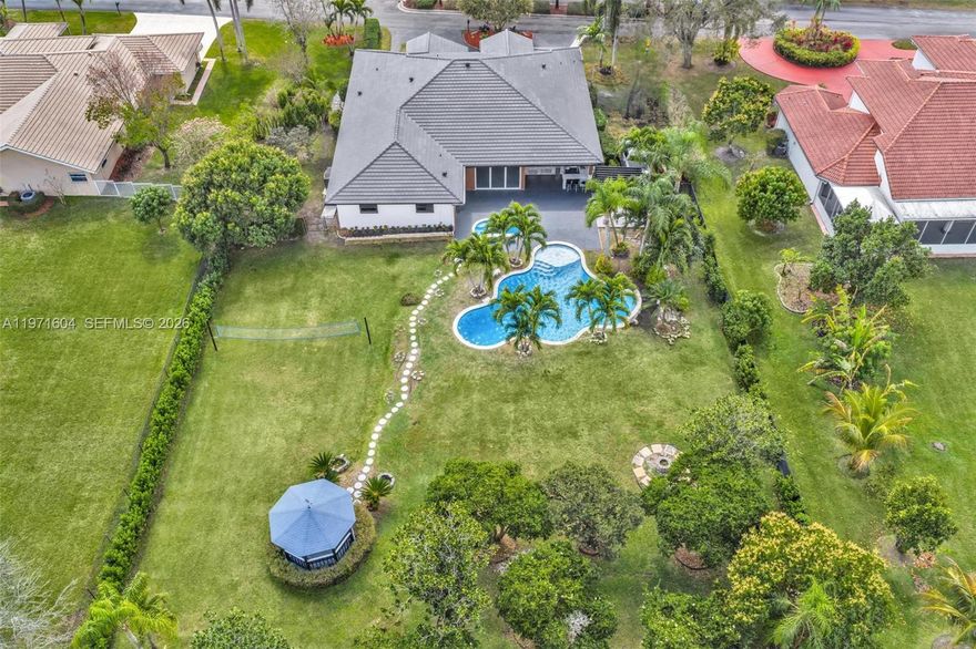 Welcome to this exceptional estate in the prestigious Kapok Village Estates in Davie. Situated on a private over one-acre homesite, this beautifully renovated 3,560 SF residence offers timeless elegance, modern upgrades, and a resort-style lifestyle with tranquil lake views. The home features 4 spacious bedrooms, 3 fully renovated designer baths, and a private office/den. Soaring ceilings, expansive living and dining areas, and abundant natural light create an open, sophisticated flow ideal for everyday living and entertaining. The reimagined gourmet kitchen showcases high-end appliances, custom cabinetry, and contemporary finishes. New flooring runs throughout, enhancing the cohesive, upscale design. Recent upgrades include full impact windows and doors and a brand-new roof for added durability and energy efficiency.
Outdoor living is equally impressive with a sparkling pool, heated spa, and fully equipped summer kitchen overlooking the water. The expansive grounds provide privacy and ample space to relax or entertain. A 3-car garage and oversized driveway offer generous parking.
Ideally located near top-rated schools, shopping, dining, major highways, and Long Key Natural Area & Nature Center, this move-in-ready estate blends prestige, comfort, and convenience in one of Davie’s most desirable communities.