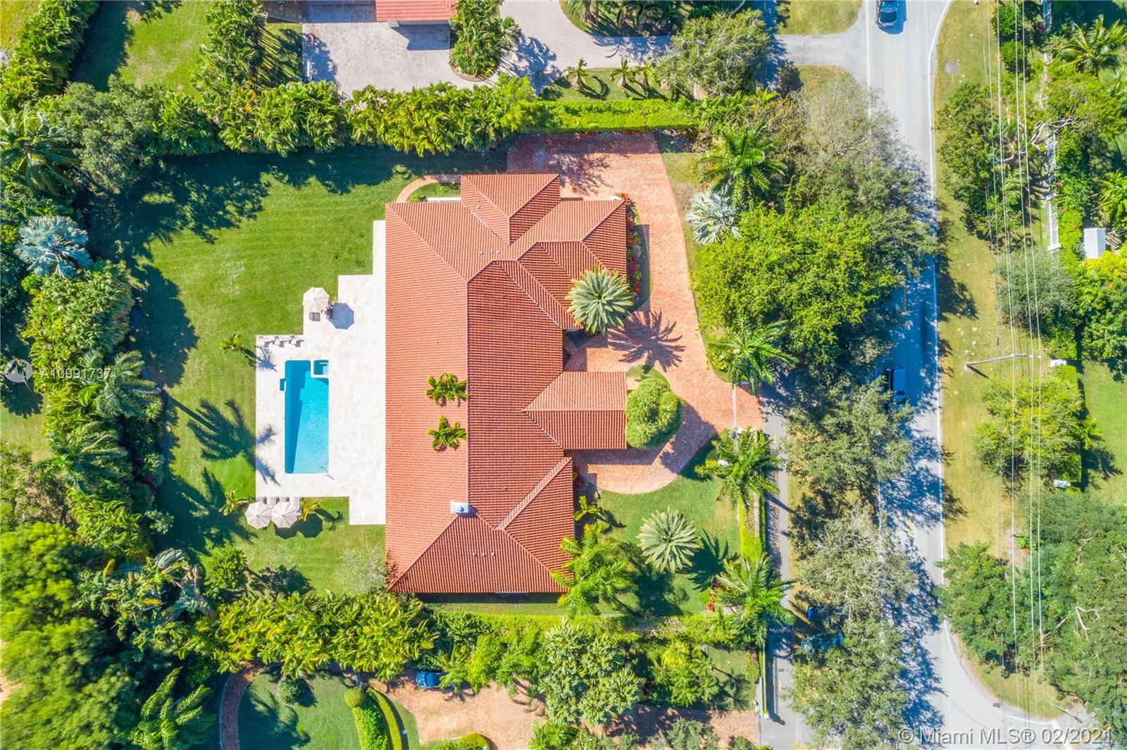 Tucked off historic Old Cutler Road, a tree-lined prestigious street in Coral Gables, a veritable paradise awaits. Here, sunlight dances across each room, lush greenery invigorates, and life unveils its most beautiful moments. Enter your gated drive with interlocking brickwork, yielding a spacious, private acre lot dotted with palms. An expansive foyer welcomes, while beyond, the one-story open plan offers endless room to play. Enjoy walk-through access to your immense backyard and inground pool, where you can cool off and sip champagne poolside. Living spaces reveal richly veined marble flooring in eye-catching contrast to bedrooms lined in lustrous dark hardwood. Decorative molding elevates crisp white walls, and drop lighting becomes a work of art in iridescent tones. Welcome home.