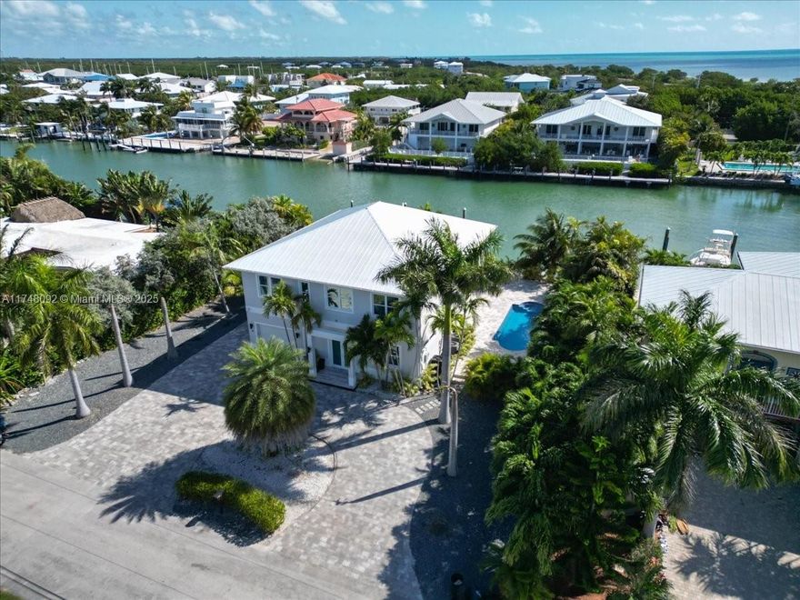 Experience luxury coastal living in this breathtaking two-story home, ideally situated along 110+/- feet of pristine canal frontage. Crafted for those who love to relax and entertain in style, this home boasts an expansive kitchen featuring a large island, updated finishes, and ample space for culinary creations. Step outside to enjoy multiple spacious patios and a large covered balcony, ideal for soaking in serene waterfront views. Natural light floods the open floor plan, creating a warm and inviting atmosphere. Boating enthusiasts will love the private boat lift, offering easy access to open waters. A circular paver driveway adds curb appeal and convenience, welcoming you home in style. Furnishings are negotiable, making this an effortless transition into your dream waterfront retreat!