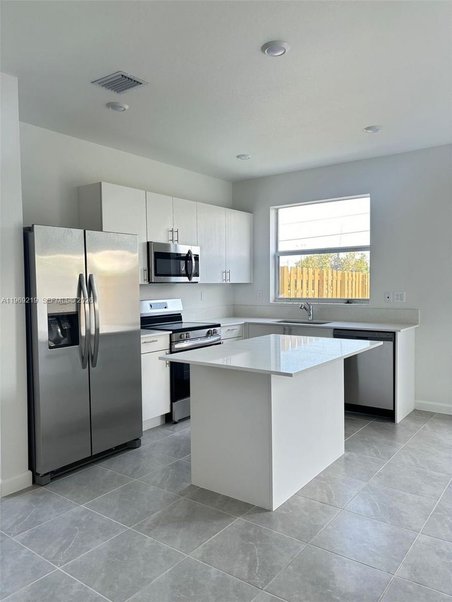 Welcome to this brand-new Townhome. Enjoy the open concept with abundant natural light and a charming patio, perfect for entertaining. This unit boasts 3 bedrooms and 3 full bathrooms, with ceramic flooring on the first floor and carpet on the second floor. One bedroom and one full bathroom are located on the first floor, ideal for guests or an office. The kitchen features a granite countertop, cooking island, and SS appliances. Just a few blocks from US1 and the Florida Turnpike, schools, supermarkets, putting you close to everything you need.  Two parking spaces right in front of the house and plenty of guest parking. Security is a priority Ring doorbell and alarm sensors. Ready to Move In. Easy to Show.