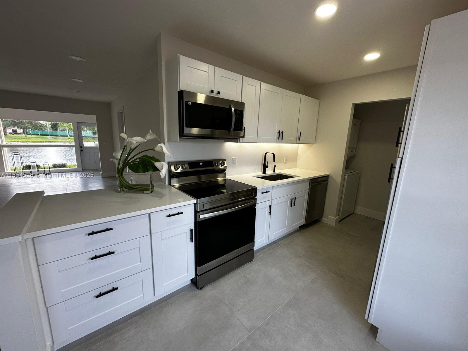 STUNNINGLY REMODELED LAKEVIEW VILLACONDO in sought-after 55+ Covered Bridge! This 1 bedroom, 2 full bath home is move-in ready with a brand-new modern kitchen featuring white shaker cabinets, quartz counters, stainless steel appliances, and sleek black fixtures. The enclosed Florida Room offers serene water views and extra living space. Both bathrooms are fully updated with designer tile and fixtures. Enjoy tile flooring throughout, a new roof (2023), and an in-unit washer and dryer. Covered Bridge provides an active lifestyle with 2 heated pools, tennis courts, shuffleboard, scenic walking paths, a clubhouse, and more. Conveniently located near shopping, dining, and major highways, this low-maintenance home combines style, comfort, and a prime location—submit your offer today!