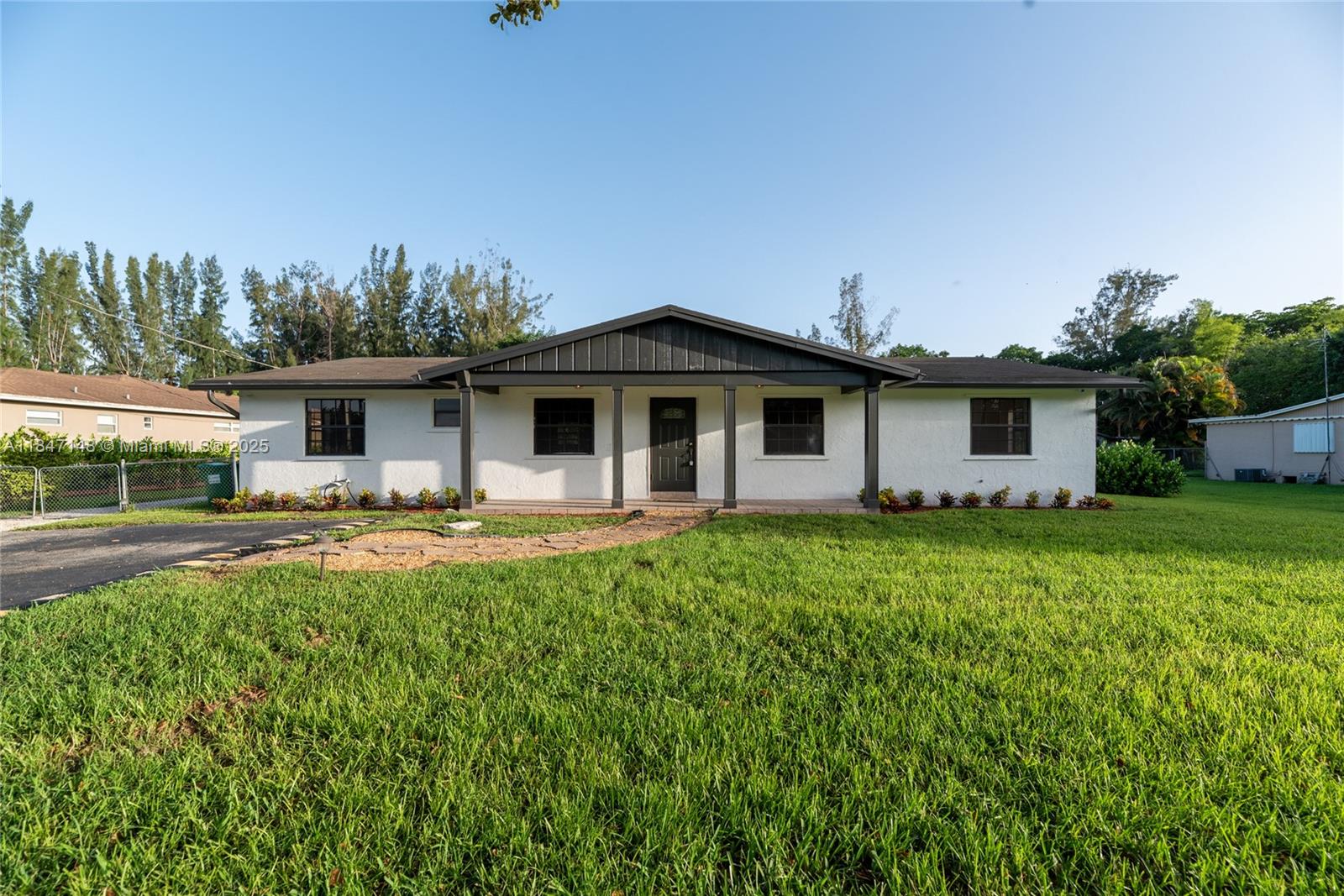 This beautiful 3 Bedroom, 2 Bath ranch-style oasis invites you into bright, open interiors set on lush, expansive grounds. Property is on almost 1 Acre of land. The sunlit living areas feature fresh white walls and luxury vinyl plank, flowing seamlessly into a modern kitchen boasting crisp white cabinetry, quartz countertops, brass finishes, and stainless-steel appliances. Step outside to a screened lanai and sparkling private pool which give you a serene retreat perfect for entertaining or relaxation. A charming outbuilding, ideal as a workshop or anything your imagination can think of, adds incredible potential. With beautifully updated finishes, generous yard space, and indoor-outdoor living that captures a tropical vibe, this home blends comfort and style into one inviting package.