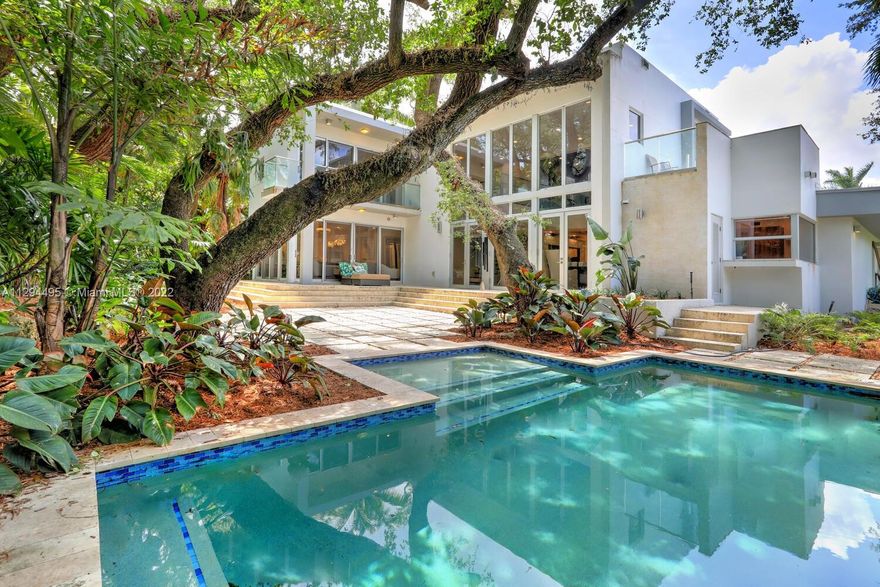 Exquisite, modern-style home in prestigious North Coconut Grove. Walk or bike to bayfront parks & marinas and to the Grove village galleries, boutiques, restaurants & sidewalk cafes. Major renovation by Kobi Karp Architecture in 2019, including a spectacular glass-enclosed wine cellar, custom built-ins and the finest fixtures & finishes throughout. 25 ft. high walls of glass provide unobstructed views from most rooms to the ultra-private tropical garden w/ magnificent Live Oaks. Unique floorplan features 2 fabulous master suites, one spanning the entire 2nd level features expansive walk-in closet, loft/office area & terrace overlooking the tree-tops. Whole house generator. 19' above sea level. Idyllic, tree-canopied pool & lounge area perfect for intimate dinners and outdoor entertaining.