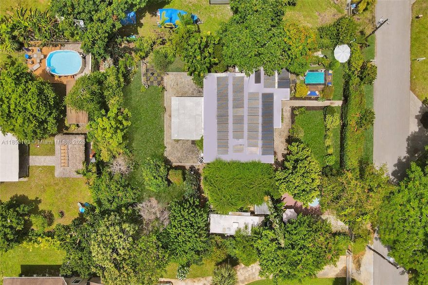 Lush mid-century 2BR/1BA+ large garage on oversized lot in quiet, flood-free Miami enclave. Immersed in a hand-planted butterfly, bee & bird sanctuary w/15+ mature edible trees incl. mango, lychee, macadamia, avocado, starfruit & bay leaf. Privacy—green views from every window, no shades needed! Solar panels, terrazzo flrs, vintage Cuban tile & cedar-beamed ceiling. Cocktail pool. Yoga deck, meditation path, Japanese garden & screened Orchid House ideal for guests. Expansive front feels like a private park perfect for entertaining. Extra drvwy fits RV/boat w/ W+E—rental/income potential. Skylit kitchen, scullery/mini kitchen, cozy guest BR & airy porch. Former wellness retreat w/room for permaculture or dream pool. Rare opportunity to own serene green space just mins from city action