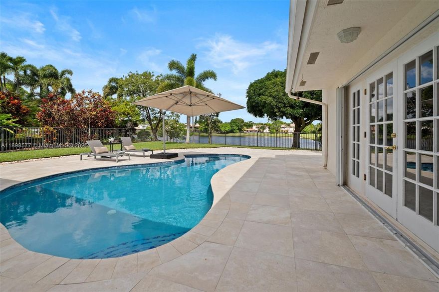 Beautiful Lakefront Family Home in Boca Raton. Enjoy stunning lake views and sunsets from this charming 5-bedroom, 3-bath home in the desirable New Floresta community. Updated with modern touches while keeping its classic style, this home offers a bright living room with marble floors, a cozy family room with fireplace, and a spacious kitchen perfect for family gatherings. Relax outdoors by the pool with jacuzzi jets, surrounded by porcelain pavers and a covered veranda overlooking the lake. The large, landscaped lot provides plenty of space for kids and pets to play. All windows and doors are hurricane protected, and the home is just minutes from Boca Town Center Mall, parks, and A-rated schools. A perfect home to raise a family and enjoy beautiful sunsets every evening.