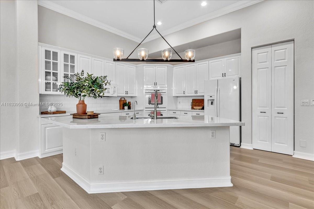 UPDATED AND MOVE-IN READY! This immaculate 4BD/3BA one-story home in Heron Bay features a modern open layout, remodeled bathrooms, luxury vinyl floors, stylish lighting fixtures, and an updated kitchen with quartz countertops and sleek backsplash. Enjoy peaceful water views from the screened patio with pergola, surrounded by lush landscaping. The oversized driveway plus 3-car garage offer parking for up to 9 cars — perfect for entertaining! Located in one of South Florida’s most sought-after communities with A+ schools, enjoy resort-style amenities including 2 clubhouses, pools, gyms, tennis, pickleball, waterpark, playgrounds, and more. Low HOA, 24/7 gated security, and an unbeatable lifestyle. This one won’t last!