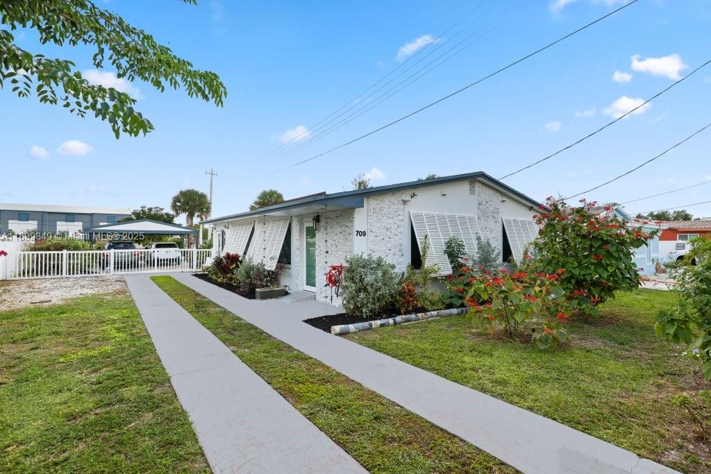 Upscale WATERFRONT home with mid-century flair in the hidden gem of Melaleuca Gardens! Enjoy total privacy on a spacious lot with an open concept layout, marble floors, high-end European cabinets, and massive windows flooding the space with natural light. Versatile den with attached bath can easily convert to a 2nd bedroom. Kitchen is perfect for entertaining with ample storage. Remodel in the last few years include roof, paint, impact/soundproof windows & doors, electrical panel, and A/C ducts, pool and water heater. Relax on the screened porch or dock your boat (fits 45'+) at the shared dock with 100 feet of seawall. For boaters - Ocean access minutes to intercoastal and inlet. Beautiful gardens. Boat/RV parking, carport. Close to the airport, shopping, beach, dining & more!