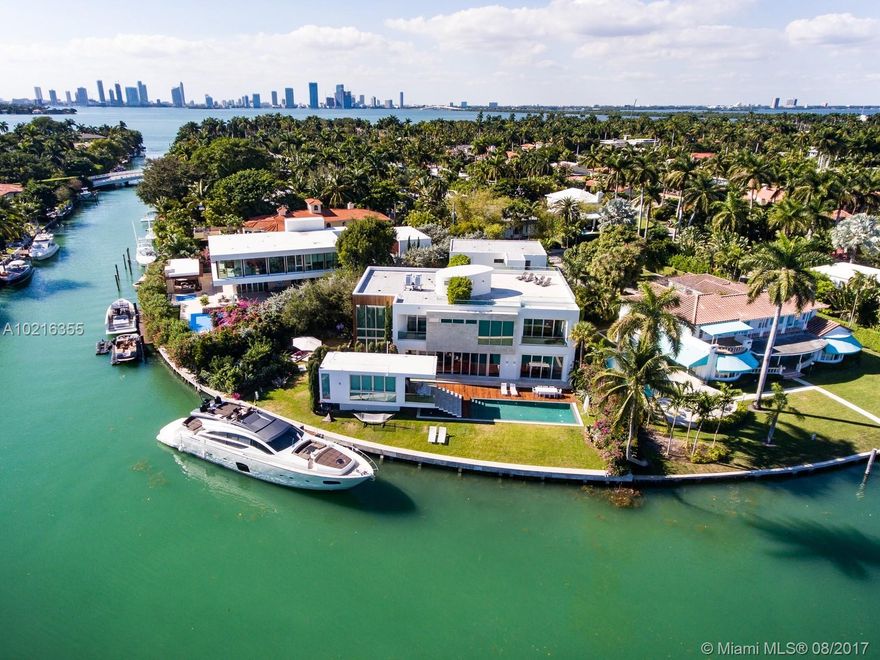 Striking modern residence built in 2013 w/150 ft of direct wtrfrnt & dock. Large lot offers wide water vus & rare dock accommodations for over 100 ft yacht. Created by sought after architect Ralph Choeff & builder Todd Glaser. Stunningly from its ground level reflection pools, light filled interiors, to the 3rd flr prvt deck, overlooking South Beach. Estate offers ideal flr plan, including a 2 bdrm attached cottage, maids quarters, 1 bdrm detached guest or Captain quarters, exercise atrium & custom garage