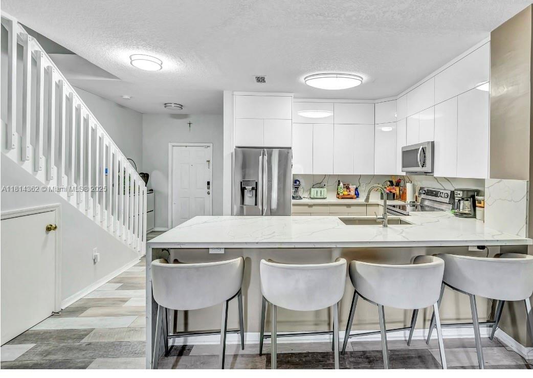 Welcome to your new home! Step inside to a stunning kitchen designed for both function and flair—complete with oversized countertops, shaker-style cabinetry, a custom-built spice rack, and a bar area with a built-in wine fridge, perfect for entertaining! Enjoy a spacious floor plan with a private garage, fully fenced in patio and a brand-new metal roof (2025)- this property checks all the boxes. Nestled in the heart of Pembroke Pines, this home is just minutes from premier shopping, dining, and entertainment, with easy access to grocery stores, major highways, and local hospital - Memorial Hospital West. No HOA approval required! Schedule your showing today and bring your best offer!