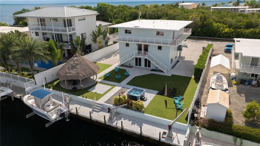 Discover this unique and versatile property in Port Largo, featuring a remarkable legal duplex with breathtaking ocean views. Each side-by-side townhome includes 2 bedrooms and 2.5 bathrooms, with all bedrooms thoughtfully designed as en-suites for ultimate privacy and comfort.  With 75 feet of waterfrontage, concrete dock with 20K lbs boat lift. The wide 80 ft deep-water canal provides direct ocean access to the world-famous Key Largo waters ideal for boating, fishing, and diving. Downstairs, you'll find a spacious 760 sq ft storage and a Tiki Hut, perfect for outdoor relaxation. Each side has its own separate electric and water meters.  Furniture negotiable. This property boasts excellent rental potential and is also perfect for two families looking to share a second home. Owner/Agent.