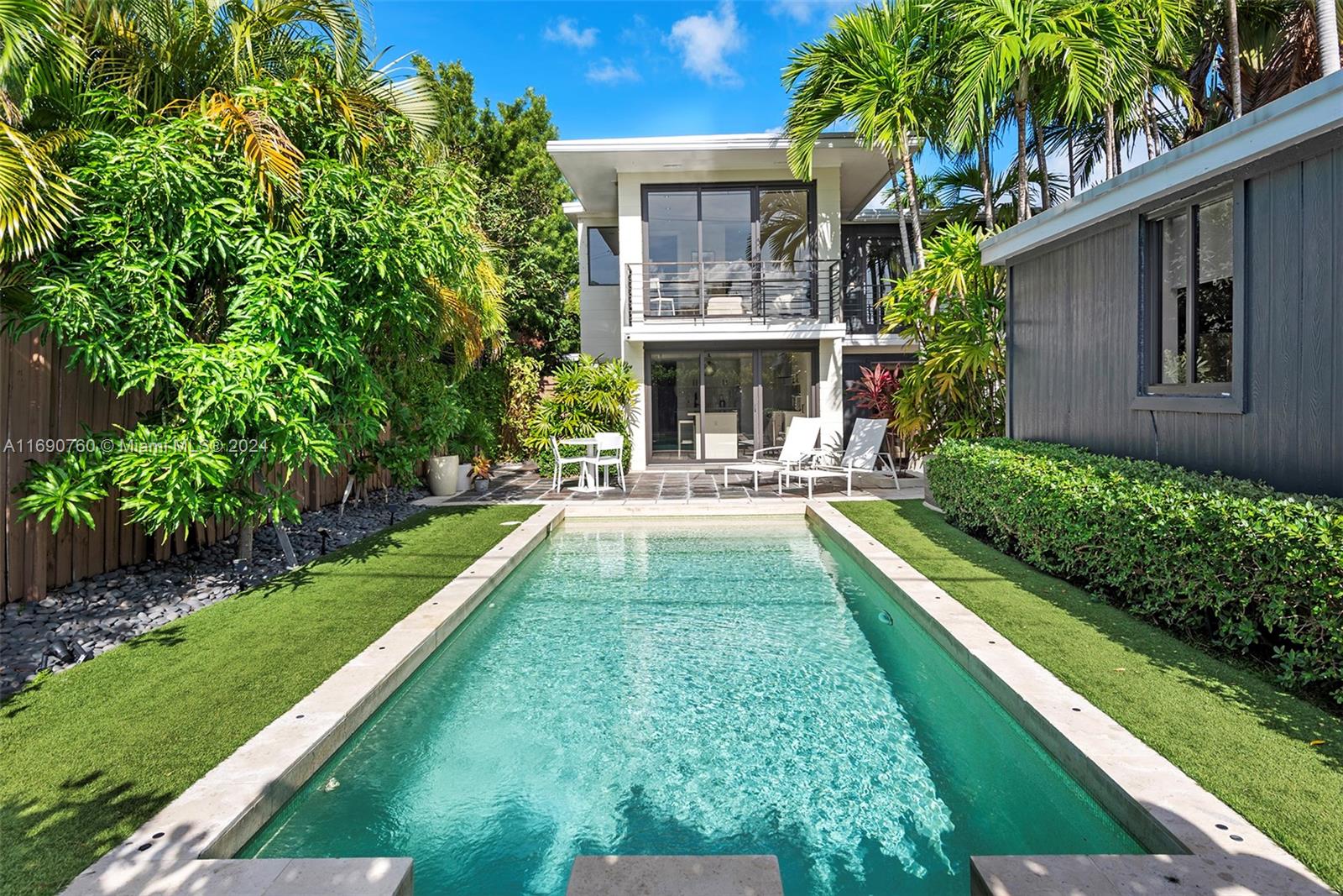 Impeccably crafted, zen-chic home built by a Frank Lloyd Wright protégé and upgraded by Nuhouse Design to amplify the quintessential Miami Beach lifestyle. An expansive entry and open staircase set the stage for the sophisticated interior. Spanning over 2,400 SF of refined living space, the main house encompasses a gourmet kitchen, a modern wood-paneled living room, 3 designer-quality baths and 3 generous bedrooms -including a decadent, spa-like primary ensuite with a spacious walk-in closet. The detached guest house (1 bed/1 bath) adds an additional 600 SF of privacy for guests, nanny or even an income producing tenant. Low-maintenance, landscaped grounds include a large, gated carpark for multiple cars, a sun-drenched pool+spa, and a tropical palm-shaded courtyard for alfresco dining.