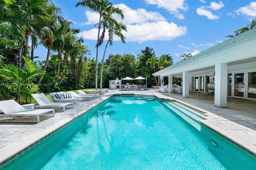 A Must See to Appreciate Expansive 15,700 sq ft tropical lot in NE Miami Shores.  Renovated in 2005. This rare-gem features a secluded backyard with an oversized pool and covered patio, lush landscaping—perfect for year-round entertaining and relaxation.  Inside, a beautiful bright, open layout with skylights, abundant natural light, and a working fireplace that adds a cozy charm. The one-car garage and circular driveway offer ample parking for family and guests. Whether you’re looking for a move-in ready retreat or a place to build, this unbeatable location offers endless potential. Don’t miss this exceptional opportunity—drive by and see the beauty of this 15,700 sq ft lot by the bay. Survey Available, Call for more details !