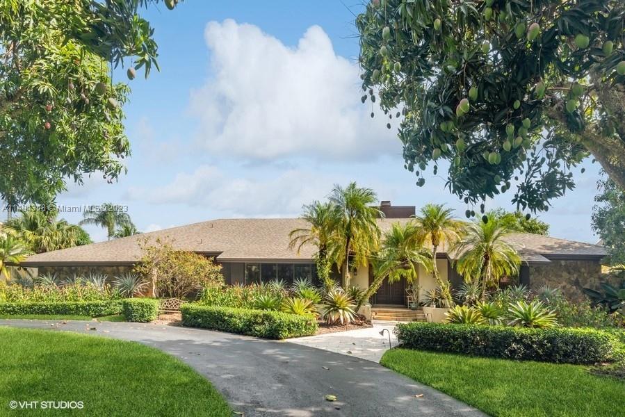Magnificent Estate Home is the essence of south Florida family living & entertaining. Situated on a secluded cul de sac w/almost an acre of lush vegetation, mango grove, & putting green. A well-designed functioning floor plan features grand living room w/huge, vaulted ceilings, wood cabinetry & fireplace. Lavish primary suite w/huge walk-in closet & spa-like luxurious bathroom! Opposite wing w/private family quarters of 3 beds/bath. Remodeled kitchen w/wood cabinets, granite counters, ss appliances, & breakfast area. Adjacent is formal dining. Additional flex room/office/den + another large library. Natural light w/huge French doors. Massive, screened patio & pool area. Separate cottage (500sqft) built 2004 w/large bed/living area, kitchen & bath + generator. Centrally located.
