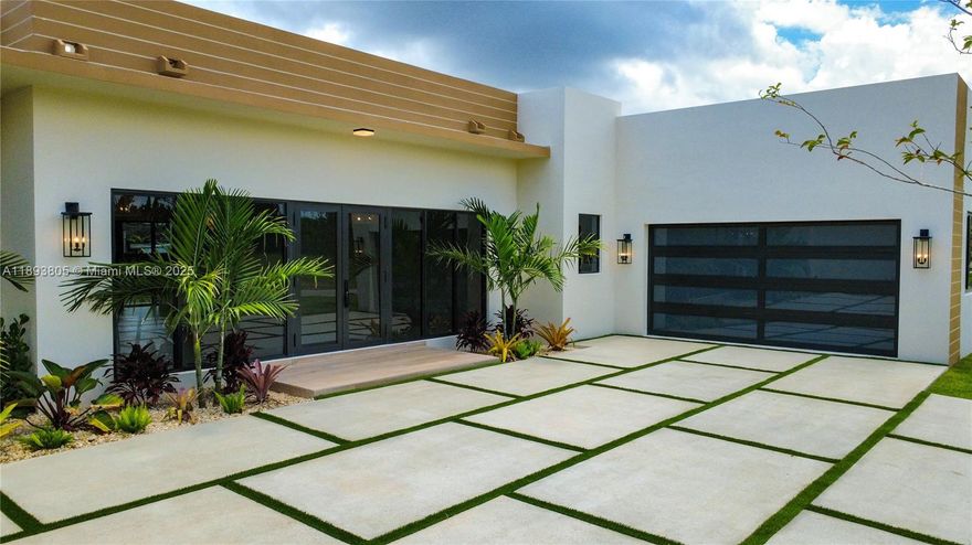 Modern luxury new construction with flat TPO roof, hurricane-impact doors/windows, and guest quarters. Spacious 16,000 sq ft lots feature a modern entrance, sealed polished concrete driveway with turf, 2-car garage, landscaped yard, irrigation system, and front/rear covered terraces. Interior offers high ceilings, porcelain floors, wood interior doors, recessed lighting, 2 tankless water heaters, 2 A/C units, and designer light fixtures. Gourmet kitchen with ceiling-height cabinets, quartz waterfall island, stainless steel cooktop, drawer microwave, hood, dishwasher, and smart refrigerator. Bathrooms with quartz vanities, main suite with glass shower and walk-in closet, plus energy-efficient washer/dryer.