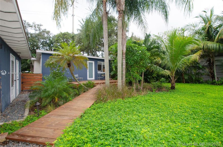 Live in your own mini Paradise!! This beautiful home is located at the end of a quiet street with a beautiful garden entrance that will make you forget all your problems! With beautiful original hardwood floors, tastefully remodeled bathrooms, an over sized lot with plenty room for a pool, and impact doors and windows. It also features a detached structure that can be converted into another room, office, etc.