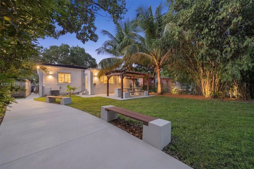 Step into the allure of this 3 bedrooms, 3 bathrooms + office room, plus a separate 1 bed/1 bath guest cottage. Located just 7 minutes from the Design District. This home is surrounded by walkable dining, cafés, gyms, yoga studios, and the MiMo District’s vibrant shops. Inside, enjoy light-filled open living spaces with high ceilings, wood floors, a stone fireplace and a Florida/media room that easily flexes as an additional bedroom. The updated kitchen flows seamlessly into the spacious dining area. The tropical backyard features a dining pergola, avocado & banana trees, and plenty of space to add a pool or expand. Charming front porch and lush gardens. additional perks includes an updated roof, AC, water heater, oversized lot, gated motorized entry & parking.