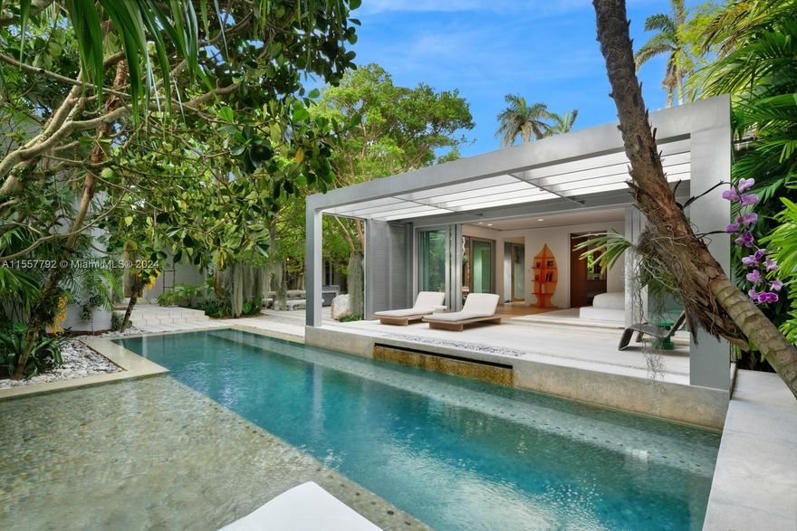 Step Inside With Me! This La Gorce Island Mid-Century Modern conveys a love of the arts, sophistication, and a simplicity to living. Curated by the famed Raymond Jungles, the tropical gardens create a sense of seclusion. Telescopic glass doors, oak floors and floating walls frame the social areas including an iconic great room, formal dining, 2 offices, and theatre room. A picture window and arched ceiling call attention to a meticulously crafted kitchen with Gaggenau appliances. The stately primary suite features a grand bath with soaking tub, dual rain showers, and lounging station. Outdoors, a whimsical setting surrounds a perfect pool + cabana while 3 driveways & a koi pond unfold to a louvered foyer + new roof. A corner location on this gated, 24-hr patrolled highly desirable island.