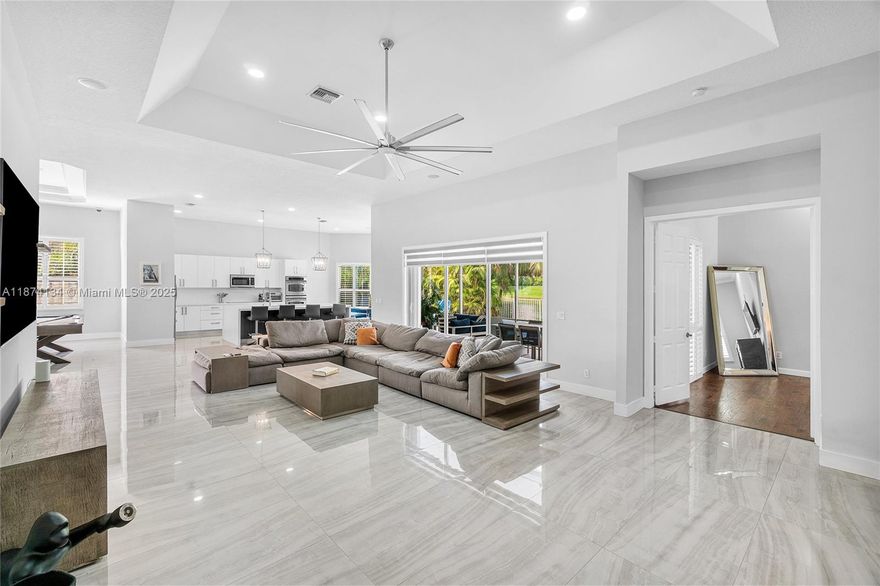 Spacious 4400+ sq ft Builder's model home! This stunning 4 bed Ranch style home offers luxury, privacy and a beautiful backyard oasis.Open floor plan with modern tile floors and a large primary suite with dual vanity sinks, oversized shower, sleek stand alone bathtub and a huge walk-in closet featuring built ins. Full Accordion hurricane storm shutters LED lighting, Custom Plantation shutters, upgraded kitchen with waterfall quartz countertops and newer GE appliances, double oven, wine cooler, Samsung smart fridge. Pool newly 2024 resurfaced with marble deck and summer kitchen. Modern pergola is perfect for entertaining! Front bay window den is perfect for a home office, flex space with built in cabinetry. 3 car garage! Volume ceilings, tons of natural sunlight. Make everyday a vacation!