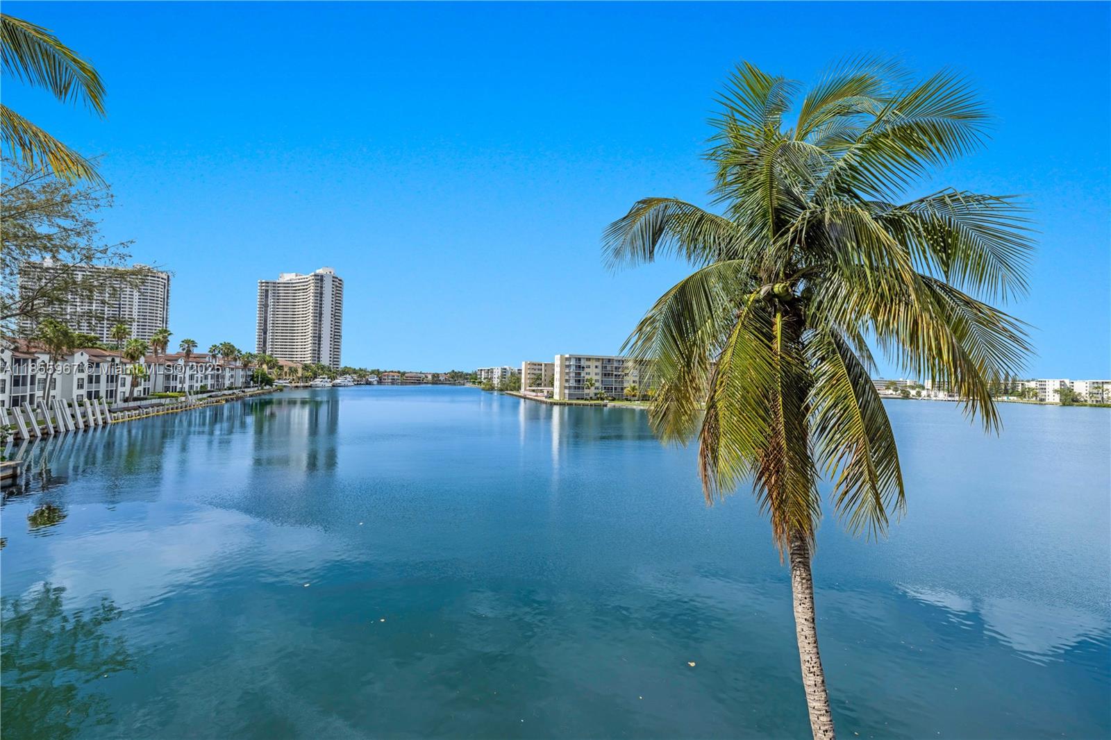 Breathtaking panoramic water views from every room of this desirable 3rd floor corner unit with wrap-around balcony. Move in ready. Immaculate 2/2.5 with updates, easily convertible to 3 bedrooms. Eat-in kitchen with sliding doors overlooking the water; washer/dryer in unit (existing in very few). Numerous large/walk-in closets. Shades on all windows; electric shades in primary (blackout) & living room slider. Space-saving Murphy bed-2nd bdrm. Glass balcony railing is part of current 40 year reno. Convenient covered parking space. Highly rated schools. Pet ok. 24/7 guard gated security, valet, 2 pools (1 heated), gym, hot tub; lit tennis/racquetball/basketball (currently being updated). Enhanced basic cable included. Near beach, houses of worship, airports, Aventura Mall, and dining.