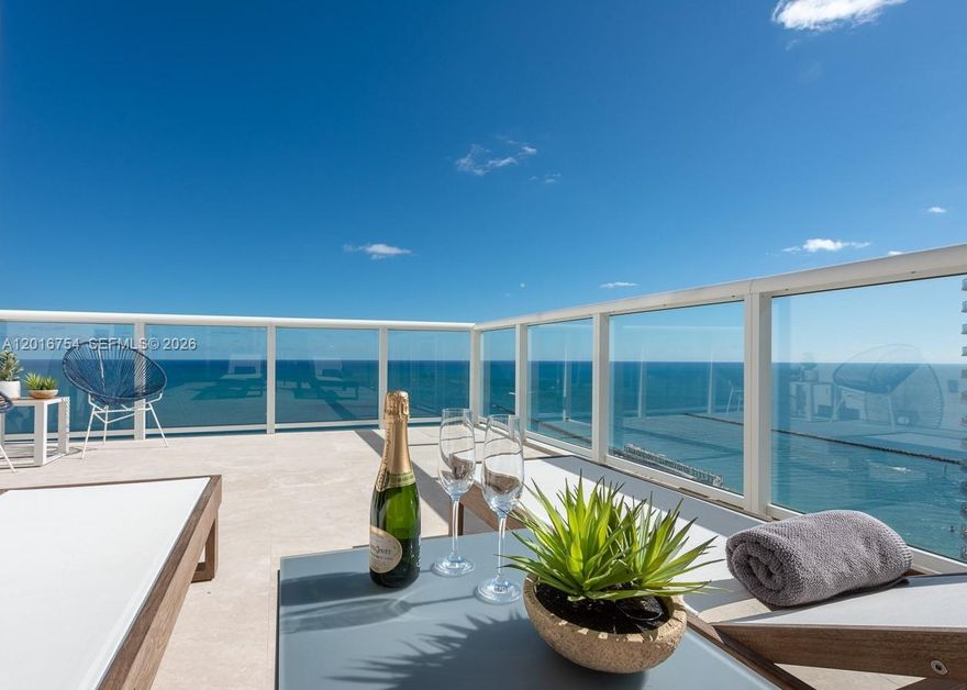 First time ever offered for rent, this exceptional flow-through SE direct oceanfront corner residence lives like a private penthouse and showcases the largest rooftop terraces in the tower. With over 3,000 SF of interior living space and nearly 1,500 SF of outdoors, the residence offers a total footprint of more than 4,500 SF of seamless indoor-outdoor living and entertaining, all framed by breathtaking panoramic views of the Atlantic Ocean, South Beach, Fisher Island, the golf course, passing cruise ships, and scenic sunset skylines. The residence features sophisticated Kreon and Luminaire lighting, curated designer furnishings, smart-home media integration, and custom Italian kitchens (MiaCuccina) and fully renovated baths. Floor-to-ceiling glass and an expansive open layout flood the home with natural light while maximizing the extraordinary views from every angle.
Residents enjoy world-class resort amenities including biometric access, a 22,000 SF wellness center with full spa services, yoga, Pilates, spinning and boxing studios, two lagoon-style pools plus a rooftop fitness pool, 3 Har-Tru tennis courts, and lush green spaces across a private 13-acre waterfront oasis. Private Italian restaurant, "Patio" offers full service  to the beach club seaside, poolside or residence, in addition the Patio's outdoor dining experince. Biometric access entry and 24/7 gaurds, doormen/ valet.  NO consturction on the North Tower, constructon on common outdoor gorunds by phase.