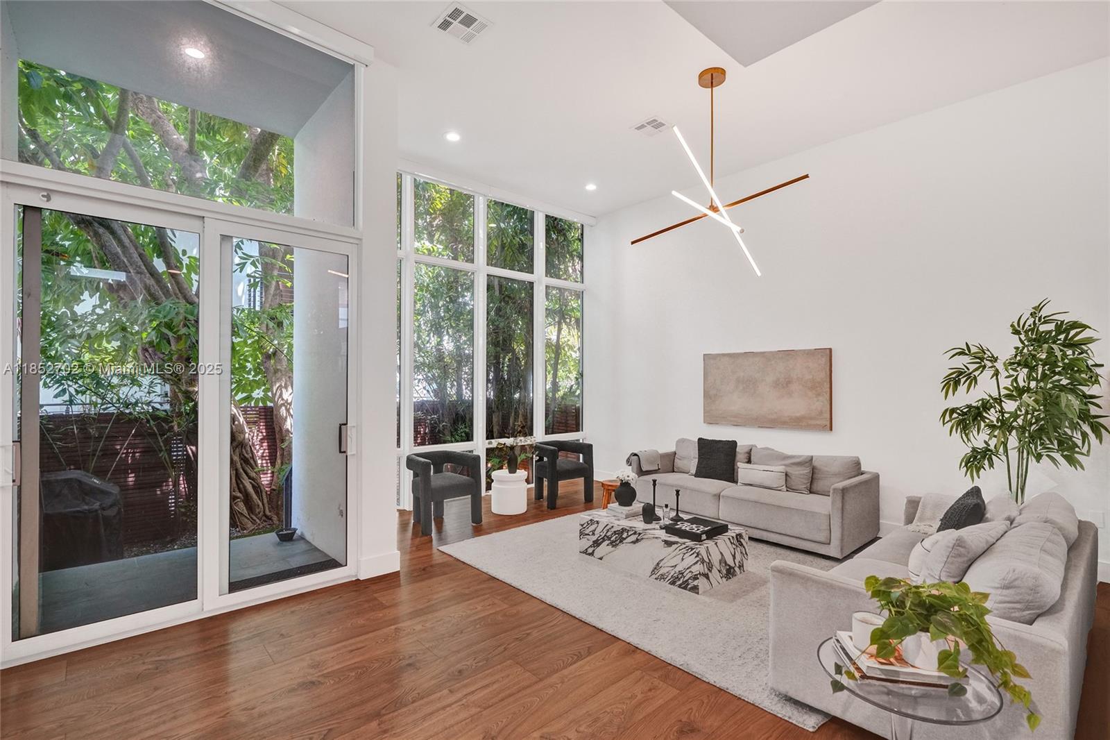 Beautifully updated tri-level townhouse in The Habitat, an exclusive 5-unit boutique community tucked away on a quiet, gated cul-de-sac. Soaring vaulted ceilings and floor-to-ceiling impact windows fill the open-concept living space with natural light. Enjoy seamless indoor-outdoor living with a private garden courtyard, spacious entertaining terrace, and access to a shared community pool. Features include a 2-car garage with tesla charger, updated interiors, and hurricane-impact windows throughout.