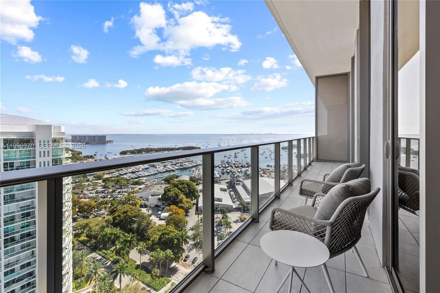 Mr. C Residences Coconut Grove – Unit 1906 is a 2-bedroom, 2-bath luxury residence spanning 1,143 total SF in Coconut Grove, Miami. Southeast-facing with direct views of Biscayne Bay, Coconut Grove Marina, and the Miami skyline from a private terrace. The residence features 11-foot ceilings, floor-to-ceiling glass, European porcelain floors, high-gloss wood millwork, Italian walnut cabinetry, Italian terrazzo and quartz surfaces, and Sub-Zero/Wolf appliances. The primary suite includes a spa-like bath, designer blackout shades, and a finished walk-in closet.Building amenities include 24-hour Cipriani-inspired concierge and butler service, resort-style pool, fitness center, resident lounge with billiards, and on-site dining. Located in Coconut Grove, Miami — minutes from Biscayne Bay marinas, Peacock Park, and CocoWalk. Includes private storage and two assigned valet parking spaces.