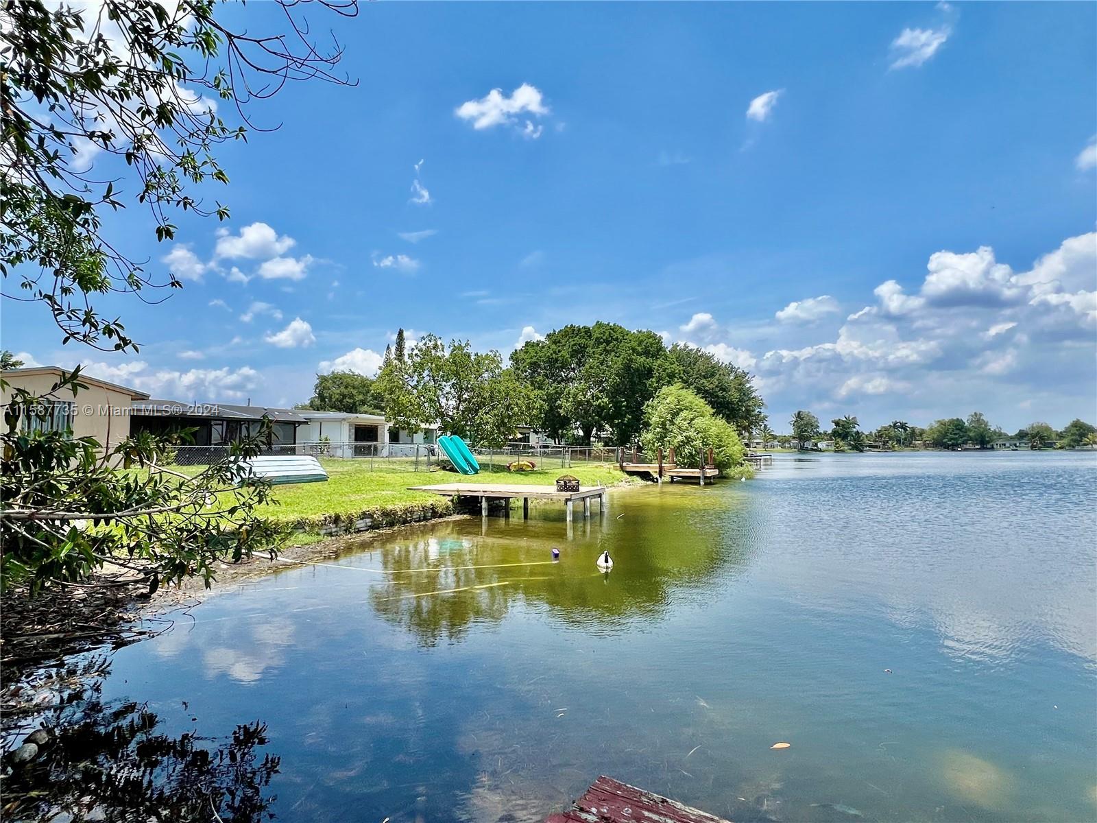Welcome to your lakeside oasis in Boulevard Heights of Pembroke Pines! Enjoy serene waterfront views and the tranquility of mature fruit trees on this property. This charming home boasts 2 bedrooms and 2 baths, with the flexibility of a garage or bonus room to suit your needs. Relax in the fenced patio area, and rest assured with ample parking available. Plus, the absence of HOA dues adds to the appeal. Conveniently located near shopping, restaurants, and more, this home offers both comfort and convenience. Don't miss out on this gem!