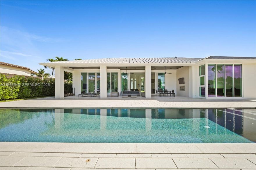 Experience elevated waterfront living in the prestigious Coral Ridge neighborhood of Fort Lauderdale. Built in 2017, this modern residence showcases clean architectural design with seamless indoor-outdoor integration, highlighted by soaring 13 ft ceilings and floor-to-ceiling low-E impact sliders that fill the home with natural light.

Designed for both luxury and functionality, the expansive covered patio (+/- 634 SF) features a tongue-and-groove ceiling, outdoor fireplace, grilling area, and spa for entertaining. The 52-foot saltwater lap pool with sun shelf runs parallel to the patio, creating a resort-style setting. Boaters will appreciate the 100-foot deepwater dock, 13k lb boat lift, direct Intracoastal access, & no fixed bridges.

Inside, the home is appointed with large-format 4’ x 4’ porcelain tile flooring, a chef’s kitchen with oversized island and BlueStar gas range, and an open-concept living space designed for gatherings. The primary suite offers a spacious walk-in closet and spa-inspired bath with dual vanities, soaking tub, and separate shower. The third bedroom has been converted into a custom wine room.

Additional features include natural gas powering key systems (stove, pool heater, outdoor fireplace, & 2 tankless water heaters), a full-house Cummins generator, AquaCal pool heat pump, newer A/C system w/ linear vents, and a durable metal roof. Multiple indoor and outdoor entertaining areas complete this exceptional South Florida waterfront offering.