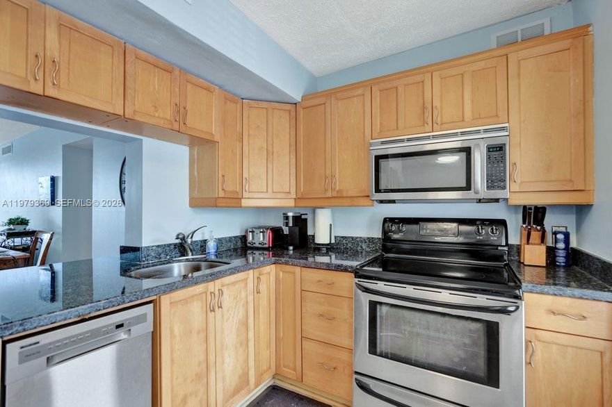 This condominium offers approximately 1,150 square feet of living space. It features two bedrooms and two bathrooms, providing ample room and privacy. The interior showcases a spacious layout with hardwood flooring throughout, creating a warm and inviting ambiance.

The primary bedroom is well-proportioned, offering abundant natural light and a serene atmosphere. The en-suite bathroom features a modern vanity and bright lighting, ensuring a refreshing and spa-like experience.

The open concept design seamlessly integrates the living, dining, and kitchen areas, promoting a sense of flow and connectivity. The kitchen is equipped with stainless steel appliances, providing a functional and contemporary cooking environment.

The large, spacious balcony offers the opportunity to enjoy the scenic outdoor and golf views and lush landscaping that surround the PALM AIRE Golf property. The covered patio extends the living space and allows for comfortable outdoor relaxation, surrounded by the tranquil greenery.

This property is located within the well-managed Palm Aire Golf Community, which provides access to multiple community pools and a host of amenities. The condominium association is known for its sound financial management and well-reserved operating budgets, ensuring a safe and well-maintained living environment.