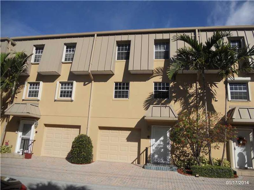 Secure tri-level townhouse within a manned gated community walking distance to the beach! This intimate community of only 18 townhomes are located on the intracoastal surrounding a lush tropical pool. The north facing patio is cool and peaceful. The impro vements include an elevator, garage, and nearly new kitchen with custom cabinets, and granite.  Dark Wood floors gleam in the natural light, and the elegant spiral stairs saves space and makes access convenient.  2-Zone A/C, deeded beach rights.