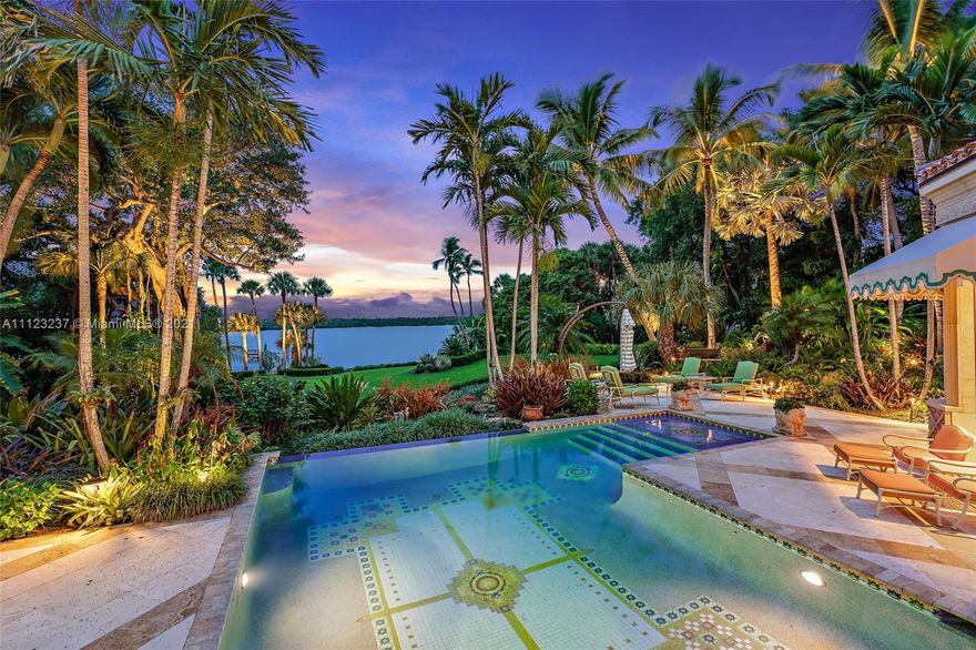 Grand Waterfront Estate with over 175' of Intracoastal Waterway. As you enter this trophy property through the winding drive surrounded by lush tropical landscaping you will feel tranquility and awe. The property is over 2 acres which is comprised of a main residence with 5 bedrooms, gym, theater, living room with fireplace, family room open to the kitchen. guest house with full eat-in kitchen, separate bedroom and bath and large family room, lastly a gate house with kitchen, bedroom, bath and family room. Enjoy countless hours in the rear yard along your own white sandy beach, relaxing under a specimen Banyan tree, sprawling lawns and manicured landscaping. This is a true masterpiece property and will not last.