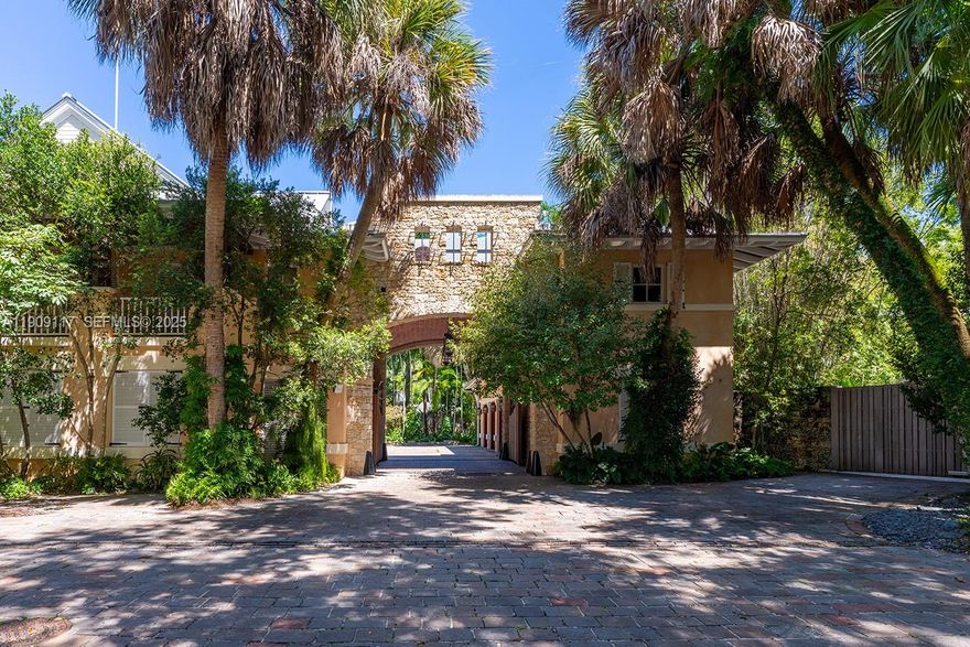 Banyan Ridge Estate is a rare architectural masterpiece where nature, architecture, and luxury converge. Set on 4.5 acres in the heart of Coconut Grove with 180 feet of direct bay frontage, this gated sanctuary in Hughes Cove/Anchorage reveals panoramic Biscayne Bay views amid cascading waterfalls, koi ponds, and lush tropical gardens by renowned landscape architect Raymond Jungles. Winding paths connect eight distinct residences and structures, each crafted with intention and artistry. Expansive terraces, meditation gardens, and hidden courtyards evoke a world-class resort ambiance, while infinity pools and a private boathouse complete its coastal allure. A timeless, tranquil, and incomparable legacy estate.