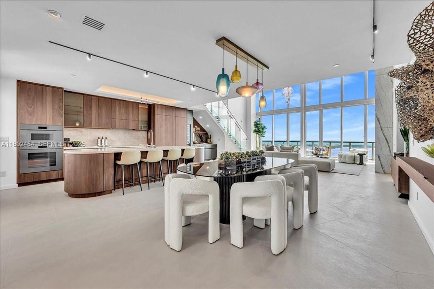 Fully renovated 2-story penthouse with Bespoke finishes and attention to every detail. Thoughtfully designed with custom finishes throughout, this residence features dramatic 20-foot floor-to-ceiling windows capturing direct east views of the ocean and Intracoastal. Highlights include imported Italian flooring, Miele and Thermador appliances, built-in wine bar, marble accent wall, Lutron lighting, Sonos system, and custom walk-in closets. The upper level showcases a spa-inspired primary suite with marble finishes, smart glass privacy, freestanding tub, steam shower, and Toto fixtures. Ideally located at Marina Blue just steps from Kaseya Center, Bayfront Park, Bayside, and minutes to Brickell, the Design District, and Miami Beach. Well-managed building with strong reserves and no assessments.