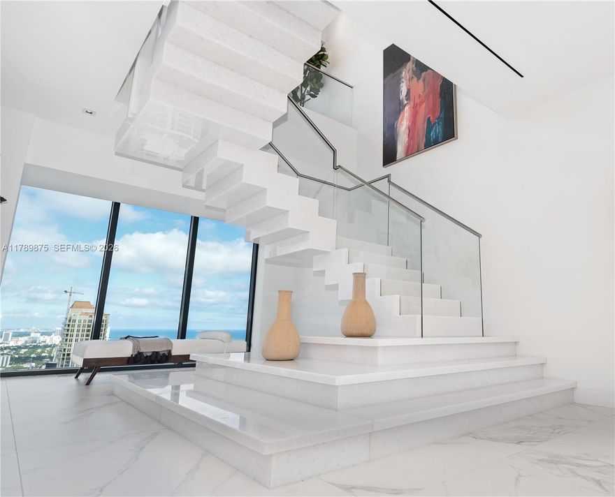 Multi Million-Dollar Oceanfront-Condo, located in Sunny Isles Beach! This two-story MASTERPIECE has phenomenal views and is the ONLY combined upper and lower duplex at the exclusive Muse Residence;includes a custom-built marble staircase,6-parking spaces and 3-Storage Units.This exquisite home has the largest interior in the building,boasts 7270 sq. ft.(under AC, larger than tax-roll). Plus Two balconies, both floors are facing EAST & also have breathtaking south, north, and west views. Exceptional for buyer who needs more condo space; can be easily converted into 7rooms. Currently has 6 en-suite rooms, including a Den room with bathroom. Kitchen has White Onyx, Italian Porcelain throughout, plus upgrades like ceiling TV-Lift & much more.