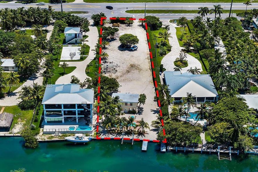 Bayside Waterfront on US1 where your dream lifestyle becomes a reality! Nearly 'Builder's Acre' (34409 SF) right in the heart of beautiful Islamorada MM77, just steps away from the vibrant Robbie's Marina area. This two-story CBS home features 2 bedrooms & 2 bathrooms, completely remodeled! Impact windows, tile floors thru-out, with an impressive 79 ft of concrete dockage complete with a lift, and sparkling pool with pavers, built in 2021 just 4 years ago! Partner with our trusted local builder, 'Native Construction,' and choose from a stunning selection of 'Spec' Homes tailored to your taste. You can opt to tear down the existing structure or design a 'Luxury Estate' right in front of the delightful two-story cottage! Don't let this incredible chance to '?Anchor in Paradise?' slip away!