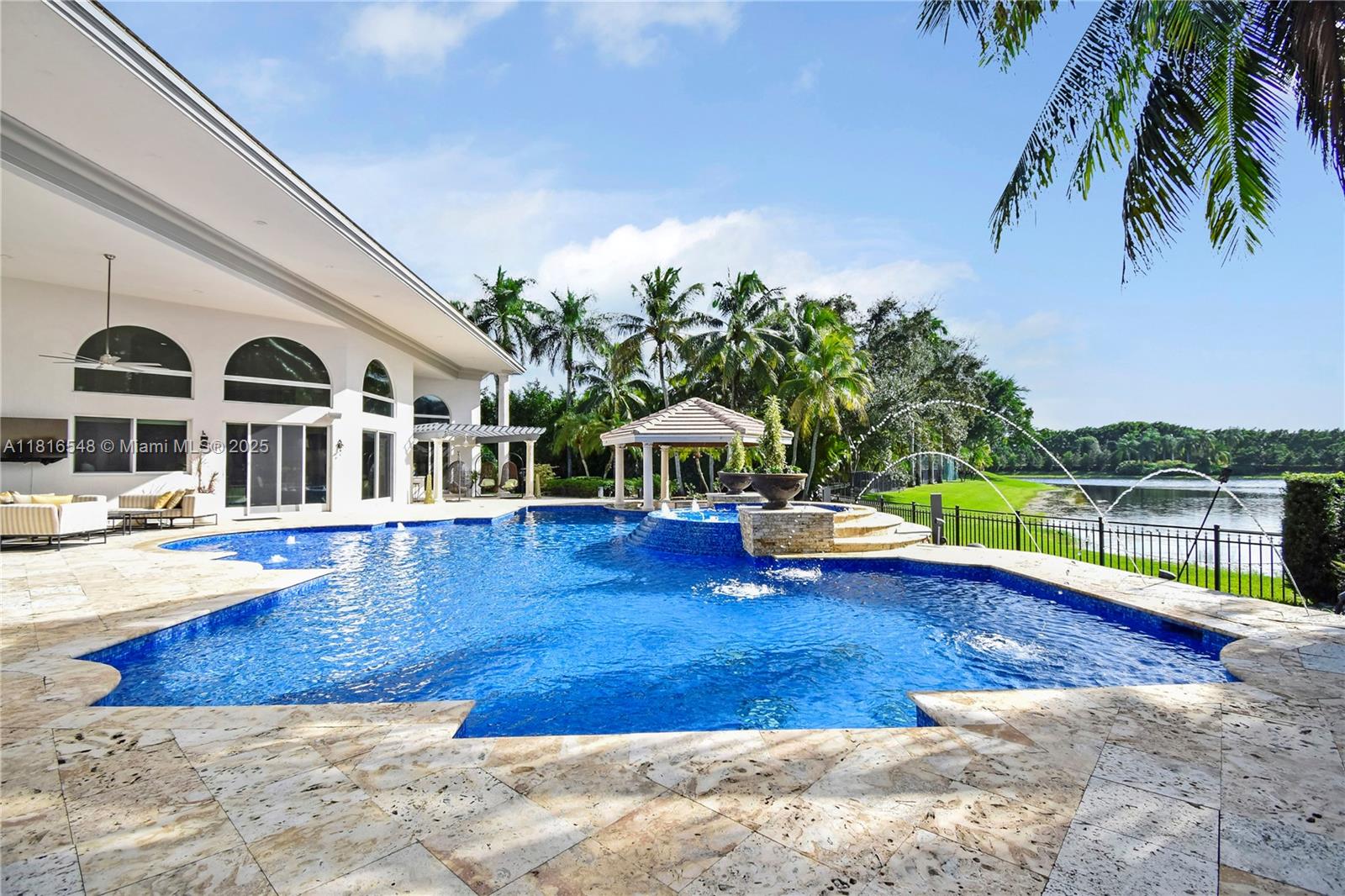 Experience unparalleled luxury in one of Weston's most exclusive neighborhoods, Windmill Ranch Estates. This extraordinary One Story Estate with 7,647 sqft2 is set on a sprawling 1.5-acre lakefront lot. This home redefines luxury living by offering 6 beds, 8.5 baths, an office, a media room, and a billiard room with a custom bar. The open floor plan boasts 20-ft ceilings, impact windows, and premium finishes. The gourmet kitchen features top-tier appliances, quartz countertops, and a double-sided fireplace. Outdoors, a lake view pool with new water fixtures, a swim-up bar, sunken gazebo, and a summer kitchen create the ultimate retreat. Recent updates include a new roof 2021, 4 A/C 2022/2023, & Sonos sound system. Option to purchase and Seller Finance available.